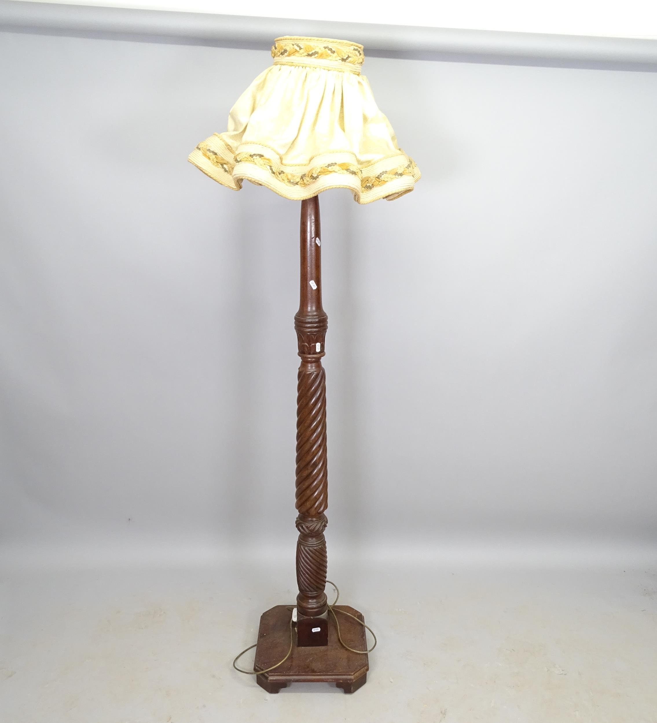 A mahogany turned wood standard lamp, on platform base, height to bayonet fitting 163cm