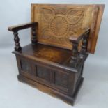 A 1920's oak carved and panelled monk's bench, with lifting seat, 91cm x 95cm x 42cm