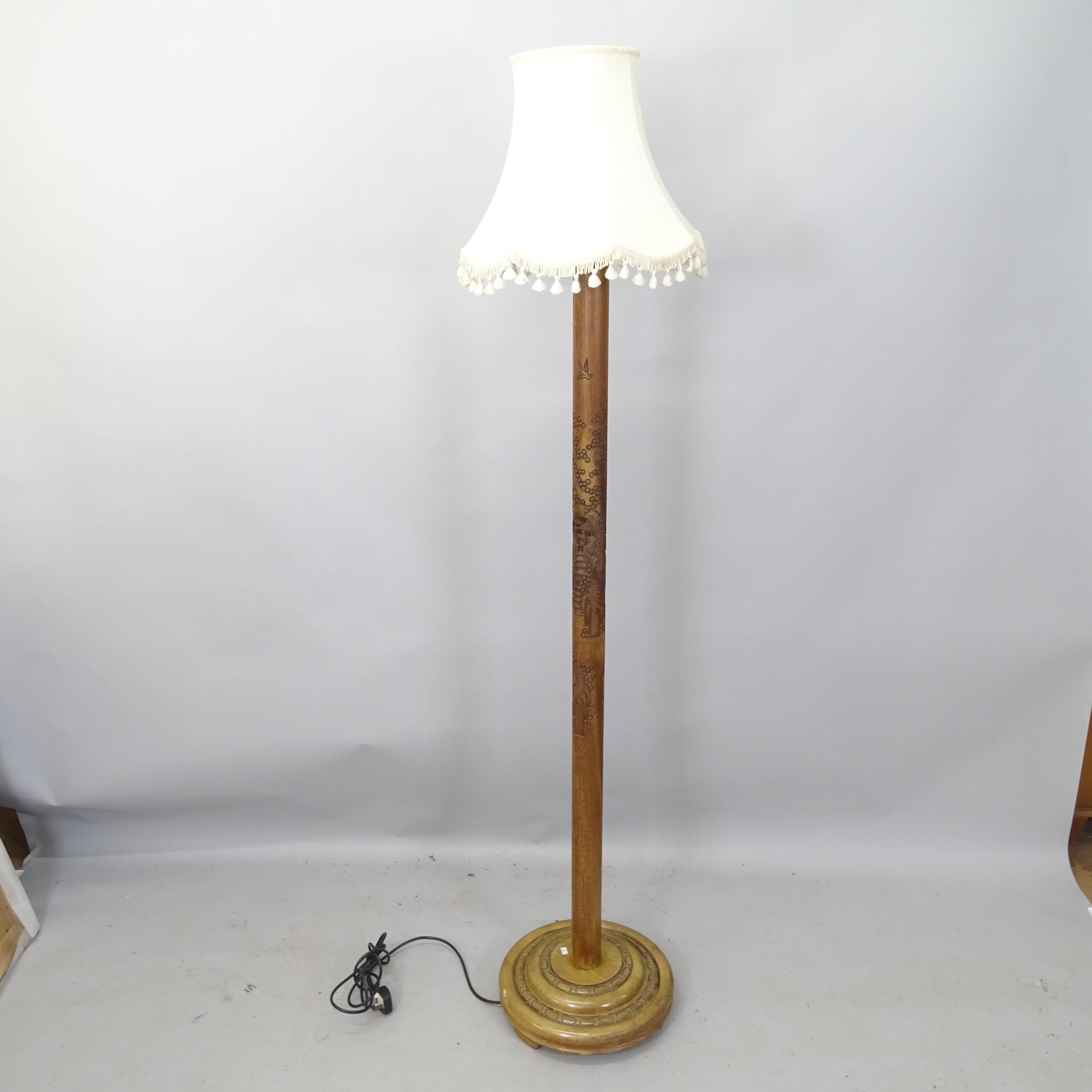 An Oriental hardwood standard lamp, with carved decoration, height to bayonet 168cm