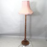 An oak standard lamp with barley twist column, height to bayonet 150cm