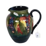 A Moorcroft jug with tube-lined fruit decoration (A/F), signed William Moorcroft, height 20cm