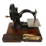 Antique Willcox & Gibbs sewing machine with gilded decoration, on plinth, with original tin for