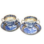 A pair of Chinese design blue and white cups and saucers, with gilded design