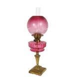 A Victorian brass and cranberry glass oil lamp (Best English Make, British made), with etched