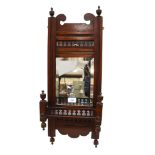 An Edwardian mahogany wall shelf, with a bevelled-edge mirror back and pierced fretwork gallery,