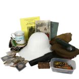 A box containing various militaria items, including various military ephemera, badges, compass,