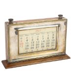 An early 20th century perpetual desk calendar, oak and manco electroplate, serial no. 9954, length