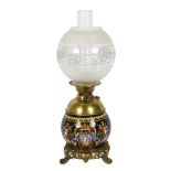 An Antique Maiolica and brass-mounted oil lamp, the font decorated with Bacchanalian scenes,