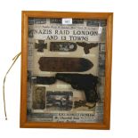 A framed display of Second World War memorabilia, including a pistol, epaulette, breast eagle etc,