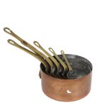 A graduated set of 6 copper pans with brass handles, largest diameter 16cm