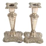 A pair of small tapered silver candlesticks, with embossed decoration, height 13cm