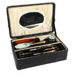 A Vintage Art Deco style vanity case, with hand painted enamel to brushes and mirrors, depicting