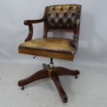 An early 20th century carved wooden button-back leather-upholstered swivel desk chair