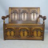 An Antique oak hall settle/monk's bench, with allover carved decoration and lifting seat, 117 x