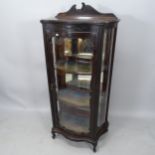 An Antique mahogany display cabinet of serpentine form, having single glazed door, 2 fitted