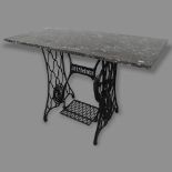 A rectangular marble-top garden table, on Singer sewing machine base, 107 x 74 x 51cm