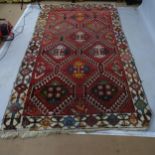 A red ground Persian design rug, 280 x 155cm Carpet has areas of heavy wear loss of pile, moth