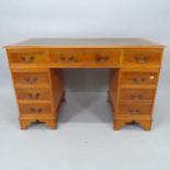 A modern yew wood twin-pedestal writing desk, with tooled and embossed leather skiver and 9 fitted