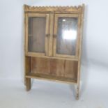 A Vintage pine hanging cabinet, with 2 glazed panelled doors, and shelf below, 64 x 105 x 17cm