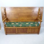 An Antique panelled oak monk's bench with lifting seat, 200cm x 120cm x 60cm, with back folded,