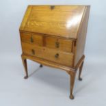 A 1920's oak lady's bureau on stand, having a fitted interior and 3 drawers under, 80cm x 106cm x