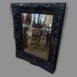A resin-framed rectangular bevel-edge wall mirror, with ornate decoration, 100 x 130cm
