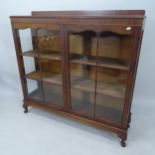 A 1930s mahogany display cabinet, with 2 glazed panelled doors and raised back on cabriole legs,