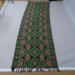A green ground wool runner with abstract design, 268 x 88cm
