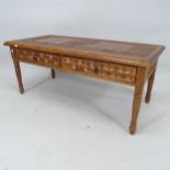 A contemporary teak coffee table with allover carved decoration, and 2 frieze drawers, 112cm x