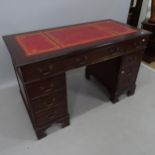 A reproduction mahogany twin-pedestal writing desk, with tooled and embossed red leather skiver, and