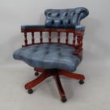 A reproduction mahogany bow-arm swivel desk chair, with blue studded faux leather upholstery