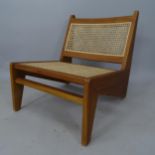 A mid-century style Kangaroo armless lounge chair, with rattan seat and back in the manner of