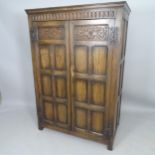 A 1930s oak 2-door compactum wardrobe, with fitted interior and carved decoration, 104 x 149 x 57cm