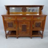 An oak Arts and Crafts sideboard, with a raised mirror-back and applied carved decoration, 155cm x