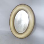 A modern oval wall mirror, with leather cushioned frame, 90 x 65cm