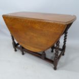 An oak oval gateleg drop leaf dining table, 106 x 73 x 50cm