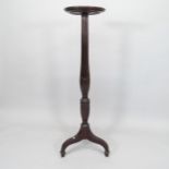 A reproduction mahogany torchere stand, with carved and fluted column on tripod base, H138cm