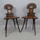 A pair of 19th century Swiss hall chairs, with ornate relief carved backs, and inlaid panels, part