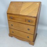 A reproduction oak bureau, the fall-front revealing a fitted interior, with 3 long drawers under, on