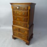 A reproduction mahogany miniature chest on chest in 1 section, having 8 fitted drawers, on bracket