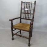 An Antique mahogany North Country style open-arm chair, with bobbin turned back and rush seat