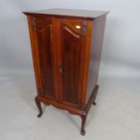 An Arts and Crafts style mahogany music cabinet, with shelf-fitted interior on cabriole legs, 52 x
