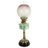 A Victorian brass oil lamp, with a cranberry and clear glass etched shade and painted green glass