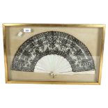 A decorative Oriental style fan, lace panelled with mother-of-pearl spines, in a display case,