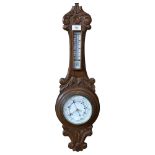 A carved oak-cased aneroid barometer with thermometer, 64cm