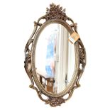 A Syroco American composition-framed oval wall mirror, height 70cm