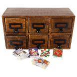 An apothecary or desk-top 6-drawer filing cabinet, each drawer contains various Christmas labels,