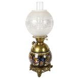 An Antique Maiolica and brass-mounted oil lamp, the font decorated with Bacchanalian scenes,