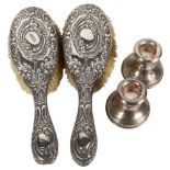 A pair of squat silver candlesticks, and a pair of Art Nouveau silver-backed dressing table brushes