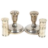 A pair of squat silver candlesticks, height 9cm, and a pair of silver plated pepper pots by Vera